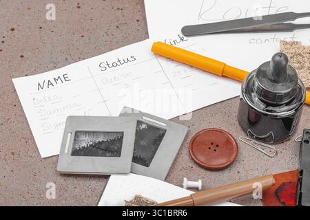 Espace de travail créatif sur le thème OSINT avec des outils vintage, des notes manuscrites et des éléments de presse sur une table grunge. Accessoires thématiques, pose à plat, espace de copie Banque D'Images