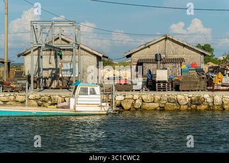Port traditionnel de l'industrie de l'ostréiculture avec bateau amarré dans le bassin d'Arcachon, France Banque D'Images