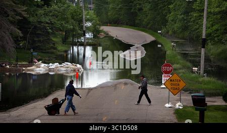 8 juin 2011 - Otter Tail County, MN, États-Unis - JIM Tail County/9 juin 2011/11 :30 AM.une forme inhabituelle d'inondation se produit dans le Minnesota, y compris dans les régions du comté d'Otter Tail, où l'eau s'écoule au-dessus du paysage parsemé de lacs depuis plusieurs années. L'eau provient de lacs alimentés par des sources sans débouchés naturels ainsi que de neige et de précipitations anormalement élevées. Dans certains cas, l'eau pénètre dans certaines maisons le long de certains lacs, et le front de mer a disparu, entraînant une chute de la valeur des propriétés. SUR CETTE PHOTO : Alice (à gauche) et Dave Wenzel ont croisé N. Little McDonald Dr près de chez eux sur Little Banque D'Images