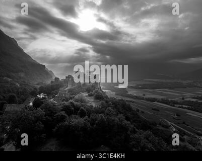 Vue aérienne du château de Miolans en France avec murs partiellement restaurés, palais, tours au ciel spectaculaire Banque D'Images