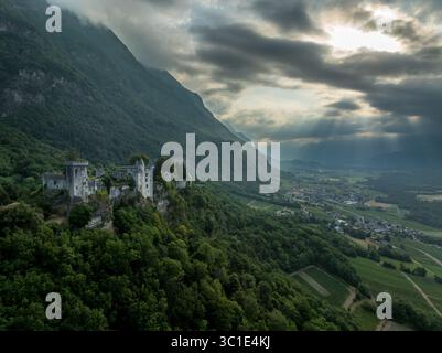 Vue aérienne du château de Miolans en France avec murs partiellement restaurés, palais, tours au ciel spectaculaire Banque D'Images