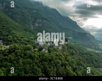 Vue aérienne du château de Miolans en France avec murs partiellement restaurés, palais, tours au ciel spectaculaire Banque D'Images