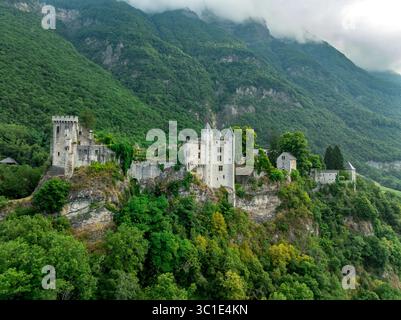Vue aérienne du château de Miolans en France avec murs partiellement restaurés, palais, tours au ciel spectaculaire Banque D'Images