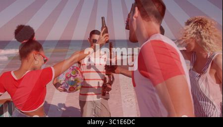 Toast groupe d'amis élevant des bouteilles brunes sur le rivage de sable, avec ballon de plage coloré Banque D'Images