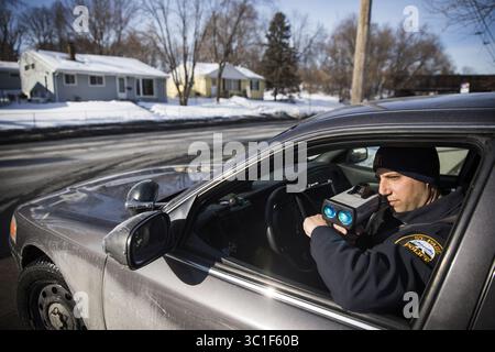 February 8, 2018 - réunissez Paul, MN, U.S.A - soyez Paul police Motor Officer John Conrad utilise un laser pour suivre la vitesse des voitures circulant sur Dale Street. ....RENSEIGNEMENTS GÉNÉRAUX : les policiers Paul, Tim Biermaier et John Conrad, patrouillent la rue Dale près du parc Marydale le jeudi 8 février 2018. Pour la première fois en dix ans, le Département de police de la Fondation Paul a une idée claire de qui est arrêté par la police avec 2017 enregistrements récemment publiés. (Crédit image : Leila Navidi/Minneapolis Star Tribune/TNS via ZUMA Wire) Banque D'Images