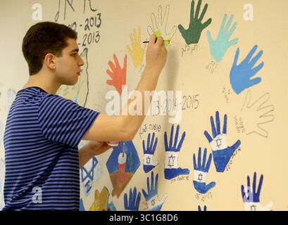 May 25, 2016 - créé Louis Park, MN, U.S. - baccalauréat International programme hébreu junior Sam Orloff peint son empreinte de main sur le mur de la salle de classe dans le cadre d'un rite annuel de passage pour juniors mercredi 5 mai 2016, à l'école Louis Park High School in mis Louis Park, MN. Depuis plus de 15 ans, le lycée Louis Park a un programme hébreu du baccalauréat International, l'un des rares dans le pays et le seul au Minnesota. Le programme est un tirage au sort pour la communauté juive de la ville ainsi que pour les locuteurs hébreux d'autres districts d'origine. Alors que le district a eu des problèmes financiers avec fu Banque D'Images