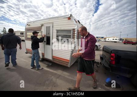 28 septembre 2011 - Minnesota, États-Unis - après avoir dormi deux nuits dans le stationnement Walmart de Williston, Dakota du Nord, Fergus Falls, Minnesota, résidents Tyson Masters, 28, Robert Hed, 27 ans, et Daniel Anderson, 24 ans, ont emballé la petite remorque de pisciculture qu’ils ont achetée pour 500 $ et se sont dirigés vers un terrain de camping voisin. Les trois ont été attirés dans l'ouest du Dakota du Nord par les nombreux emplois créés par le boom pétrolier. Les noms sont l à R Tyson Masters, 28, Robert Hed, 27 et Daniel Anderson, 24, sont cq des sujets. (Crédit image : Glen Stubbe/Minneapolis Star Tribune/TNS via ZUMA Wire) Banque D'Images