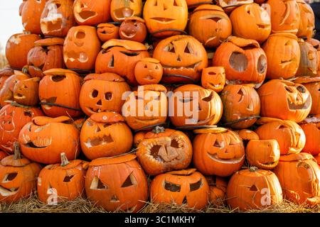 Pile de citrouilles d'Halloween sculptées avec des visages drôles et effrayants Banque D'Images