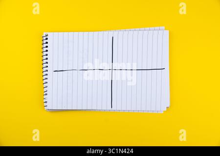 Cahier en spirale avec des pages vierges et des lignes noires sur fond jaune pour des notes personnelles ou des idées de brainstorming, analyse SWOT dans le bloc-notes Banque D'Images