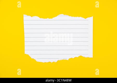 Papier carnet ligné déchiré sur fond jaune vif pour l'école ou le bureau Banque D'Images