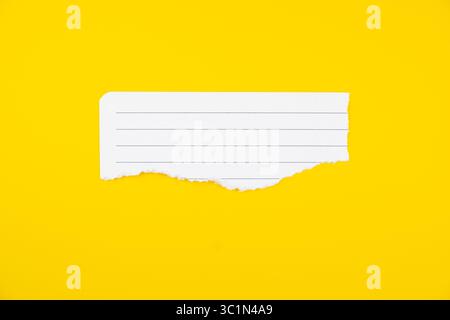 Note de papier lignée de bord déchiré avec espace blanc sur fond jaune vif pour écrire des rappels ou des messages Banque D'Images