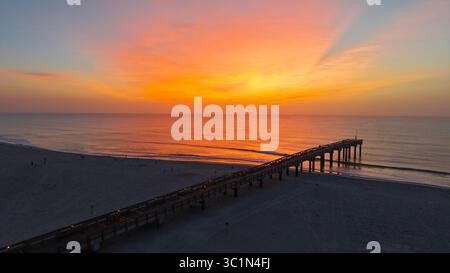 Vue aérienne de la jetée de long Saint Johns County qui s'étend dans l'océan sous un ciel vibrant lever de soleil, Saint Augustine Beach, Floride, États-Unis. Banque D'Images