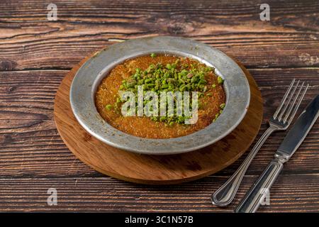 Kunefe traditionnel avec pistaches sur une table en bois Banque D'Images