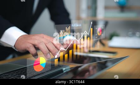 Analyse des données commerciales avec des graphiques futuristes, une ligne de tendance montante et des mains professionnelles sur ordinateur portable, symbolisant la croissance, l'investissement et la fin numérique Banque D'Images