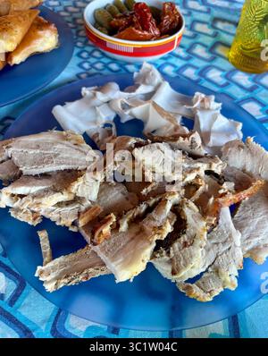 Coupes de saindoux typique salé de Colonnata et porchetta rôtie de porc dans une assiette bleue. Salami traditionnel de la cuisine italienne. Directement au-dessus. Banque D'Images