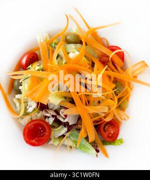 Salade de légumes frais et sains de carottes, laitue, tomates, olives et radicchio sur fond blanc. Nourriture végétarienne ou végétalienne. Directement au-dessus. Banque D'Images