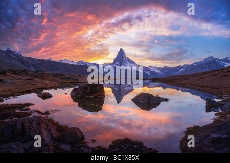 Stellisee et Matterhorn sont peints à la lumière spectaculaire dans des couleurs vives pendant le coucher du soleil suisse. Pic emblématique de Cervino reflété dans un lac alpin tranquille au-dessus de Zermatt Banque D'Images