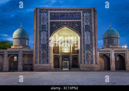 Tachkent, Ouzbékistan - 05 avril 2024 : vue sur le serein complexe Hazrati Imam, avec ses dômes turquoises et son système de titillage complexe qui brille doucement contre le ciel crépusculaire. Banque D'Images