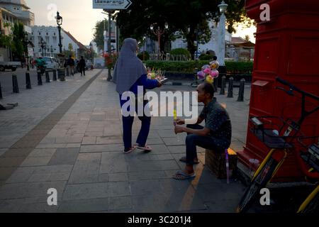 Semarang, Indonésie - 25 juillet 2024 : un vendeur de jouets et un vendeur de nourriture de rue à Kota Lama Semarang, Indonésie, une zone historique du coloni néerlandais Banque D'Images