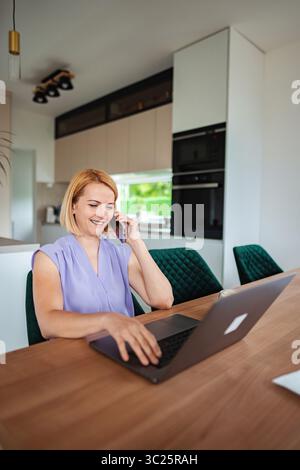 Travailler à domicile pendant un après-midi ensoleillé dans la cuisine Banque D'Images