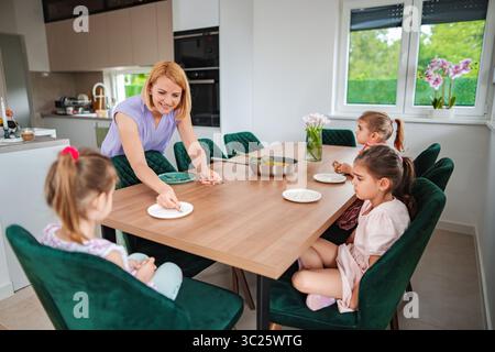 Les enfants apprécient un repas ensemble dans un cadre de cuisine confortable Banque D'Images