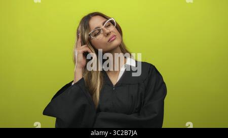 Femme juge en robe noire pointant le doigt vers la tempe tout en ajustant les lunettes dans le studio photo ; concentration de pensée. Banque D'Images