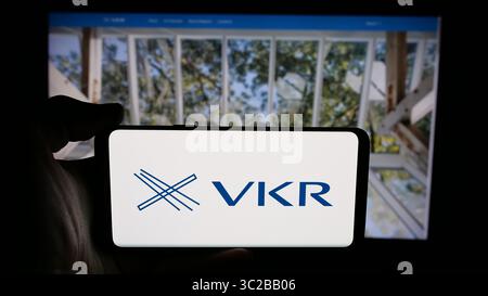 Stuttgart, Allemagne - 31-05-2025 : personne tenant un téléphone portable avec le logo de la société danoise d'investissement VKR Holding COMME sur l'écran en face de la page Web. Banque D'Images