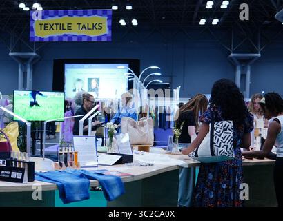New Yor, États-Unis. 23 juillet 2025. Les participants peuvent voir des échantillons de textile sur un stand d'exposition lors de Texworld NYC, le plus grand salon d'approvisionnement textile de la côte est des États-Unis, à New York, aux États-Unis, le 23 juillet 2025. POUR ALLER DE L'AVANT AVEC « veille économique : l'incertitude tarifaire nuit aux décisions d'approvisionnement en vêtements aux États-Unis », disent les experts de l'industrie crédit : ADA Zhang/Xinhua/Alamy Live News Banque D'Images