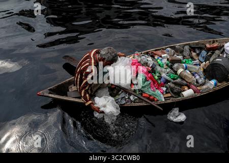 7 avril 2019 - Dhaka, Bangladesh - Un homme récupère une bouteille en plastique dans la rivière polluée Buriganga à Dhaka, au Bangladesh. La rivière Buriganga, qui longe la ville de Dacca, est actuellement l'une des rivières les plus polluées du Bangladesh. La ville de Dhaka déverse environ 4 500 tonnes de déchets solides chaque jour et la plupart d’entre eux sont rejetés dans le Buriganga. L'eau de cette rivière est maintenant tellement polluée que tous les poissons sont morts, et la saleté croissante et les déchets humains l'ont transformée comme un gel noir. Même ramer à travers la rivière est maintenant difficile car ça sent si mal. (Crédit image : © Kazi Salahuddin/ZUMA Wire/ZUMAPR Banque D'Images