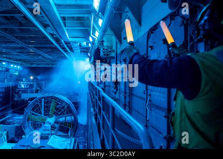 28 mai 2019 - États-Unis - le matelot Juan Rivera, d'El Paso, Texas, signale au pilote d'un coussin d'air d'engin de débarquement (LCAC), affecté à l'unité d'embarquement d'assaut (ACU) 5, alors qu'il pénètre dans le pont du navire de transport amphibie de classe San Antonio USS John P. Murtha (LPD 26). John P. Murtha en est actuellement à son déploiement inaugural et fait partie du Boxer Amphibious Ready Group (ARG) et de l'équipe de la 11e Marine Expeditionary Unit (MEU) et est déployé dans la zone d'opération de la 7e flotte pour soutenir la stabilité régionale, rassurer les partenaires et alliés, et maintenir une présence postulée pour répondre à tout c Banque D'Images