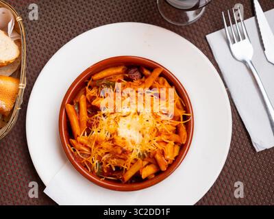 Pâtes cuites au four avec chistorra, poivre, oignon et croûte de fromage croustillante. Banque D'Images