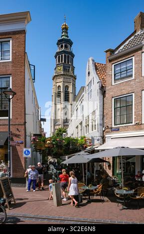 Middelburg, Zeeland, Niederlande - Fussgaengerzone Korte Delft an der Ecke Reigerstraat. Die kleine immer wieder geschmueckte Gasse, hier Vogelbauer, in der Altstadt ist eine Sehenswuerdigkeit der Stadt. In der Umgebung gibt es viele CafÃ s und Geschaefte. Hinten der Tall John Abbey Tower, ein restaurierter Kirchturm aus dem 14. Jahrhundert mit 207 steinernen Stufen zu einer Aussichtsgalerie. Middelburg Zeeland Niederlande *** Middelburg, Zeeland, pays-Bas zone piétonne Korte Delft au coin de Reigerstraat la petite ruelle décorée à plusieurs reprises, ici Vogelbauer, dans la vieille ville est une Banque D'Images