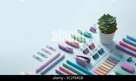 Bannière de papeterie avec des fournitures de bureau de couleur pastel soigneusement disposées sur fond bleu clair. Place pour votre texte. Banque D'Images