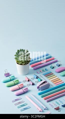 Fond vertical avec papeterie de couleur pastel soigneusement disposé sur un fond bleu clair. Espace pour votre texte. Banque D'Images