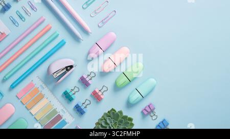 Bannière de papeterie avec des fournitures de bureau de couleur pastel soigneusement disposées sur fond bleu clair. Place pour votre texte. Banque D'Images