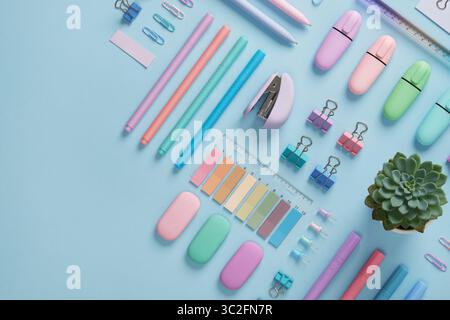 Bannière de papeterie avec des fournitures de bureau de couleur pastel soigneusement disposées sur fond bleu clair. Place pour votre texte. Banque D'Images