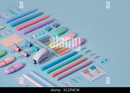 Bannière de papeterie avec des fournitures de bureau de couleur pastel soigneusement disposées sur fond bleu clair. Place pour votre texte. Banque D'Images