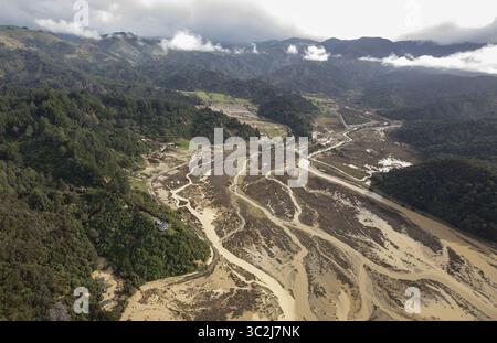 Vue aérienne d'une rivière tressée creusant à travers une vallée inondée, flanquée de collines verdoyantes sous un ciel nuageux, Motueka, région de Tasman, Nouvelle-Zélande. Banque D'Images