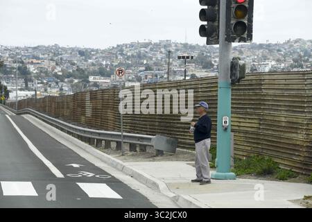 25 juin 2019 - San Diego, CA, États-Unis - Un piéton attend à un feu le long de la frontière entre les États-Unis et le Mexique près du port d'entrée de San Ysidro mardi 25 juin 2019, à San Diego. (Crédit image : © Denis Poroy/ZUMA Wire) Banque D'Images