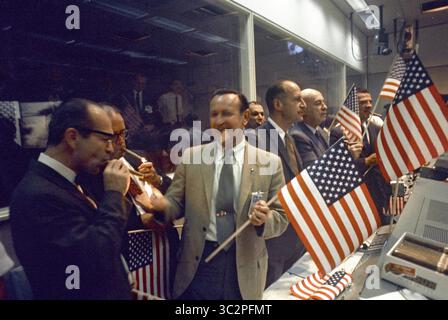 24 juillet 1969, Houston, Texas, États-Unis : les responsables de la NASA et du Centre spatial habité (MSC) se sont joints aux contrôleurs de vol pour célébrer la conclusion réussie de la mission Apollo 11 dans le Centre de contrôle de mission. De gauche au premier plan Dr MAXIME A. FAGET, MSc Directeur de l'ingénierie et du développement ; GEORGE S. TRIMBLE, MSc Directeur adjoint ; Dr CHRISTOPHER C. KRAFT Jr., MSc Directeur des opérations aériennes ; JULIAN SCHEER (à l'arrière), Administrateur adjoint, Bureau des affaires publiques, QG DE la NASA ; GEORGE M. LOW, Directeur, Apollo Spacecraft Program, MSc ; Dr ROBERT R. GILRUTH, MSc Directeur ; et C Banque D'Images