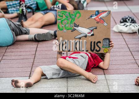 26 juillet 2019, Munich, Bavière, Allemagne : un enfant participant à un Die In organisé par le groupe extinction Rebellion tient une pancarte à l'aéroport international de Munich pour protester contre le transport aérien. Lors d'une vague de chaleur en Europe qui a battu des records, des militants du groupe extinction Rebellion ont organisé un délit à l'aéroport international de Munich au début des vacances d'été afin de sensibiliser aux émissions de CO2 des compagnies aériennes...extinction Rebellion, également connu sous le nom de â€œXRâ€ organise des actions de désobéissance civile afin de protester contre ce qu'ils affirment être un â€œecocideâ€ en cours, en formulant des revendications Banque D'Images