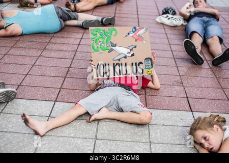 26 juillet 2019, Munich, Bavière, Allemagne : un enfant participant à un Die In organisé par le groupe extinction Rebellion tient une pancarte à l'aéroport international de Munich pour protester contre le transport aérien. Lors d'une vague de chaleur en Europe qui a battu des records, des militants du groupe extinction Rebellion ont organisé un délit à l'aéroport international de Munich au début des vacances d'été afin de sensibiliser aux émissions de CO2 des compagnies aériennes...extinction Rebellion, également connu sous le nom de â€œXRâ€ organise des actions de désobéissance civile afin de protester contre ce qu'ils affirment être un â€œecocideâ€ en cours, en formulant des revendications Banque D'Images