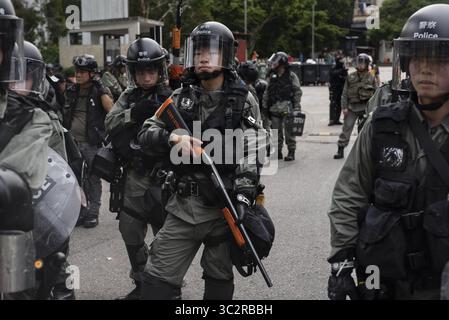 27 juillet 2019, Hong Kong, Chine : des policiers anti-émeutes se tiennent sur leurs gardes lors des affrontements avec les manifestants. Des milliers de manifestants poursuivent leur manifestation antigouvernementale hebdomadaire exigeant du gouvernement qu'il retire totalement le projet de loi sur l'extradition et mette en place une commission indépendante pour examiner les problèmes de l'utilisation disproportionnée de la force contre les manifestants et des liens avec des membres de gangs locaux pour attaquer les manifestants la semaine dernière. La manifestation a eu lieu dans le district de Yuen long où les manifestants ont été brutalement attaqués par une foule de membres de gangs habillés de blanc la semaine dernière. (Crédit image : © Migu Banque D'Images