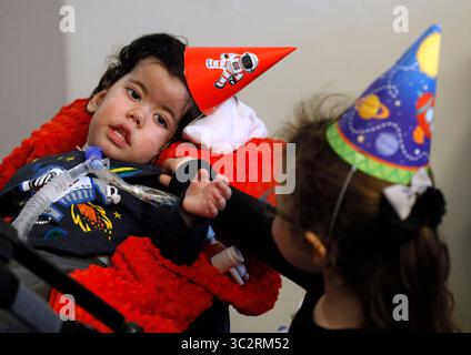 29 janvier 2017, Melbourne, Floride, États-Unis : Jamie Townshend, 2, et sa sœur, Quinn, se tendent la main pendant la fête du cinquième anniversaire de Quinn dans leur maison de Melbourne le 29 janvier 2017. Townshend a une myopathie myotubulaire liée à l'X, un trouble neuromusculaire génétique rare. (Crédit image : © Tampa Bay Times via ZUMA Wire) Banque D'Images