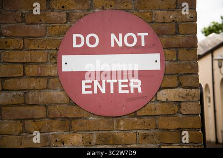 Panneau rouge « NE PAS ENTRER » monté sur un mur, servant d'avertissement clair ou d'avis d'accès restreint dans une zone publique ou privée. Banque D'Images