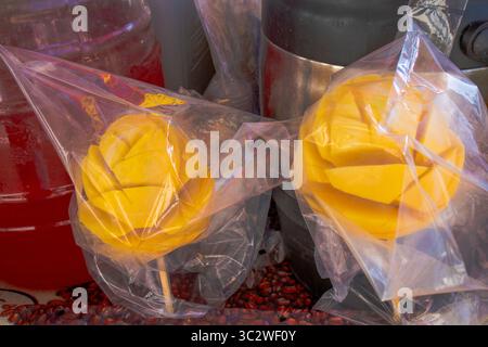 Mangues sur un bâton, enveloppées dans du plastique, en vente dans un chariot de vendeurs ambulants au Tuesday Farmer's Market à Santa Barbara, en Californie. Banque D'Images