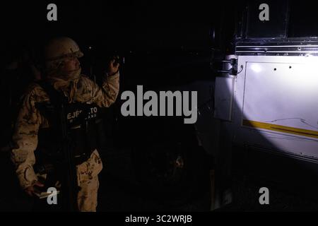 Un soldat inspecte un véhicule près de Ciudad Juarez pendant une opération de sécurité frontalière de nuit. Banque D'Images