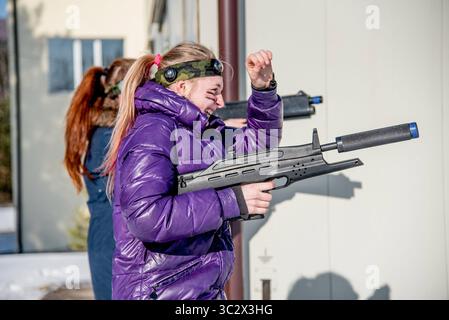 Krasnoïarsk, Russie, 7 mars 2017, enfants jouant au paintball à l'extérieur dans le parc en hiver, joueur caché derrière une barrière artificielle Banque D'Images