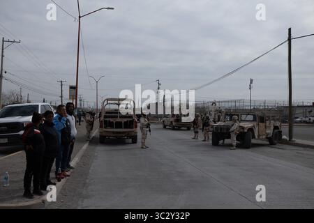 Des civils regardent les troupes patrouiller une zone sécurisée à Ciudad Juarez au milieu de la montée de la violence urbaine. Banque D'Images