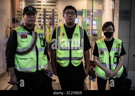 Août 18, 2019, Hong Kong, Hong Kong SAR, Chine : un groupe d'ambulanciers de premiers secours observe le mars par les manifestants..toke protestataires dans la rue sur un dimanche pluvieux dans une manifestation pro-démocratie sur l'île de Hong Kong, ils exigent le retrait complet de la loi sur l'extradition et le gouvernement à mettre en place une enquête indépendante sur les récents affrontements entre manifestants et policiers - Les organisateurs ont déclaré que c'était le plus grand rassemblement au cours de la semaine. (Crédit Image : © Ivan Abreu/SOPA des images à l'aide de Zuma sur le fil) Banque D'Images